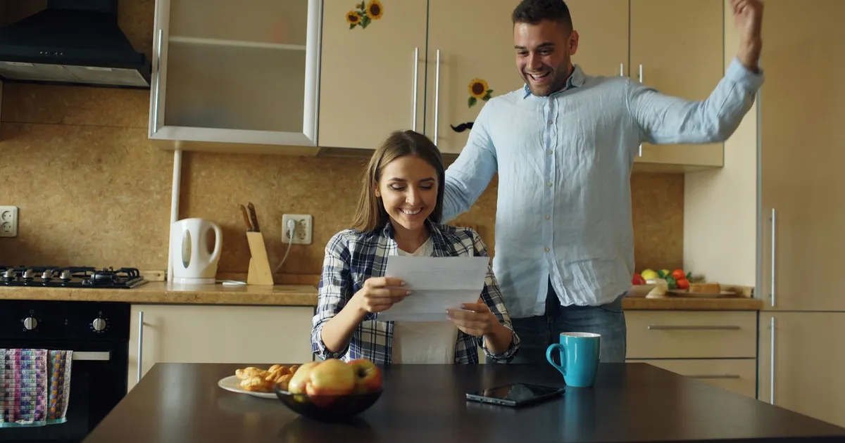 Person giving a thumbs up while reading a 100% approval loans decision on their phone
