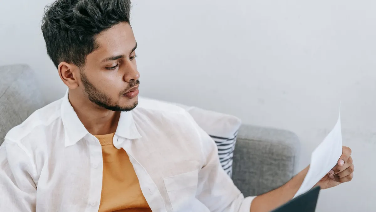 Young man reviewing installment loan payment options at home