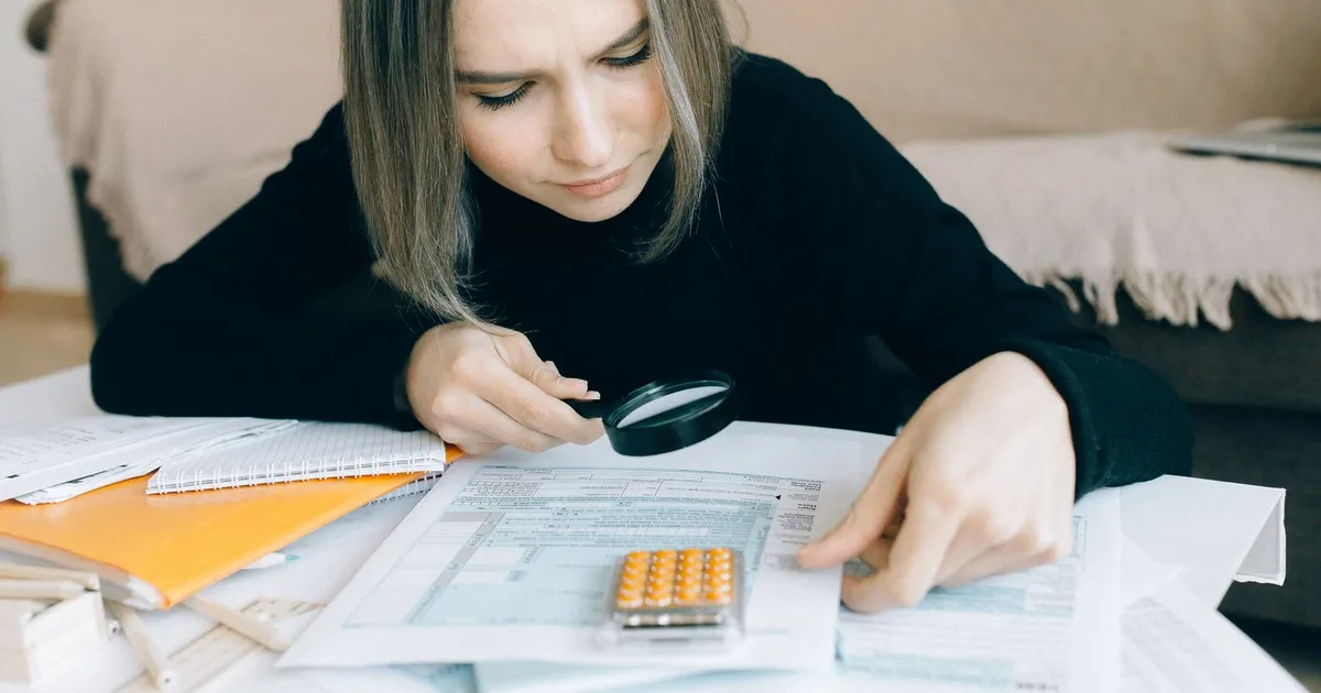 Woman reviewing consumer proposal loans and payment documents at her kitchen table