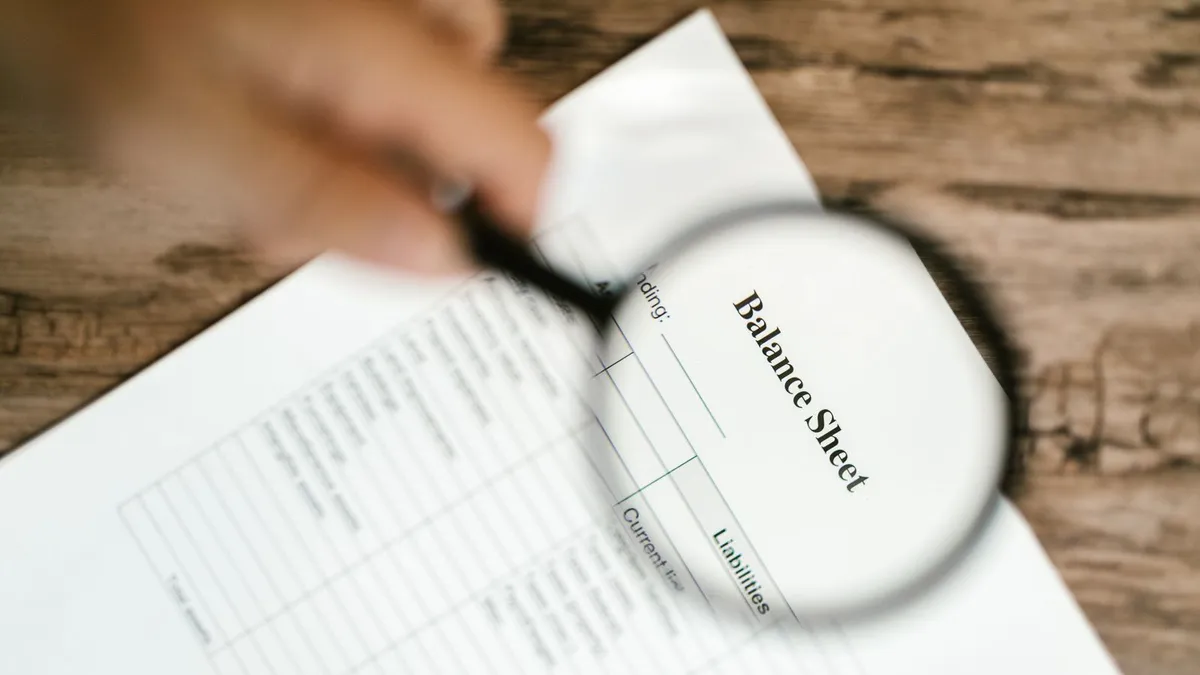Magnifying glass over a loan agreement to check the lender licence number and address