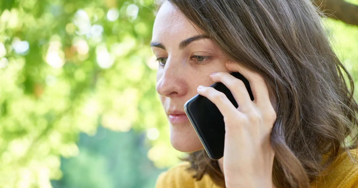 Person looking suspiciously at a phone call from someone claiming to offer a loan, a common sign of loan scams in Canada