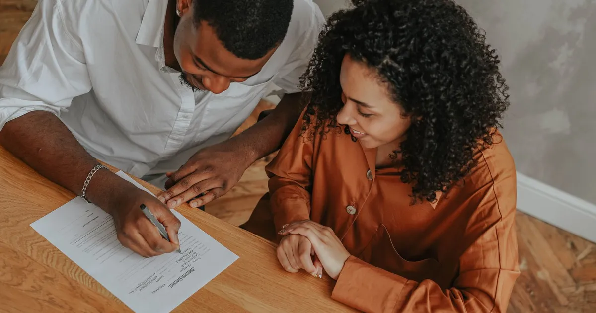 Relieved Canadian couple reviewing loans after bankruptcy paperwork at their kitchen table