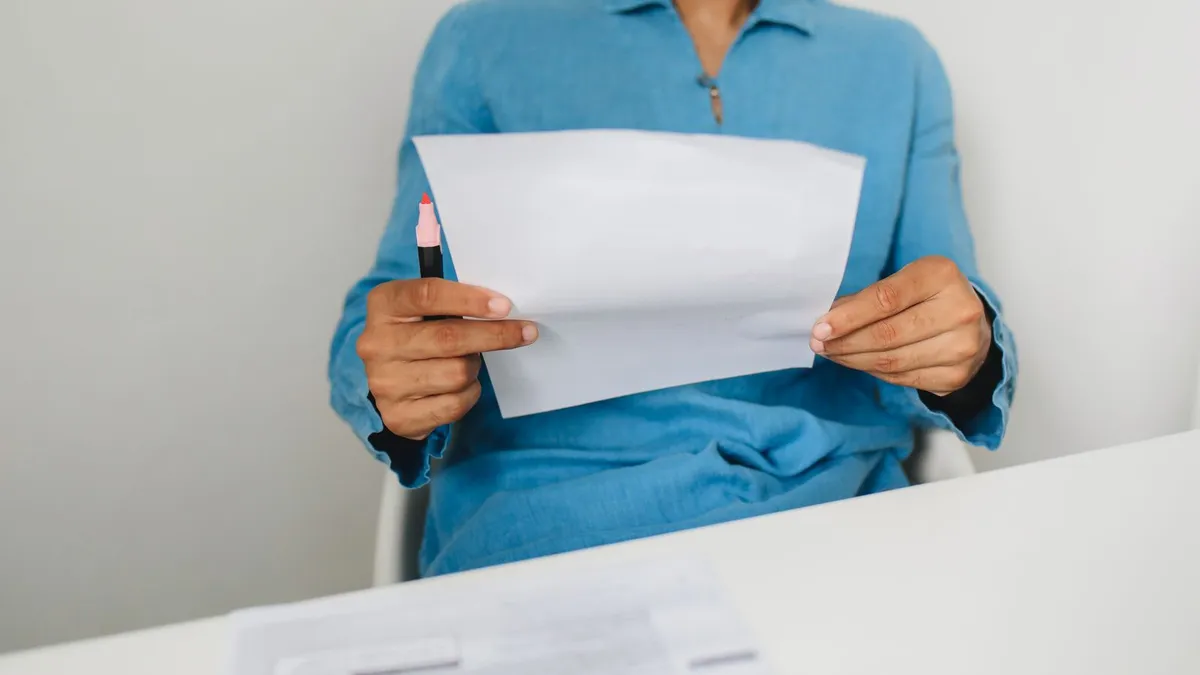 Man at home reading a letter about his benefit deposit before applying for a loan