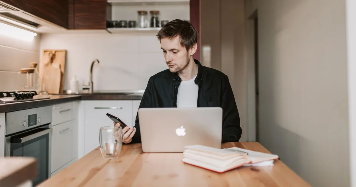 Person searching for jobs on a laptop at home while comparing loans for unemployed Canadians