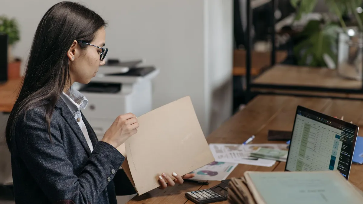 Woman calculating her net pay and budget at a kitchen table to work out how much she can borrow